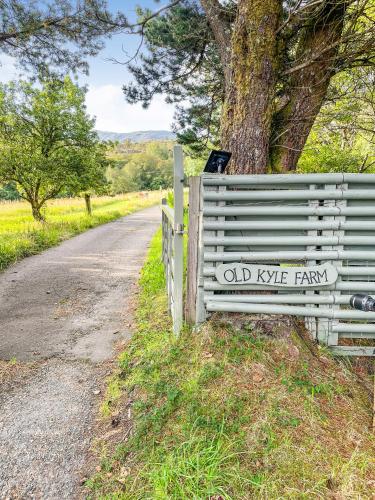 an old knife farm sign on a fence next to a road at Old Kyle Farm - Stunning Views - 2 mins from Skye Bridge in Kyleakin