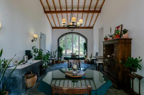 a living room with a table and a large window at Monte Ingles in Ponta Delgada