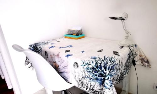 a table with a lamp and a white chair at Vue magnifique, piscine privée chauffée et sauna à 10min de Monaco in Roquebrune-Cap-Martin