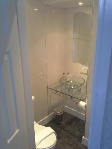 a bathroom with a glass sink and a toilet at Arundel House in Whitby