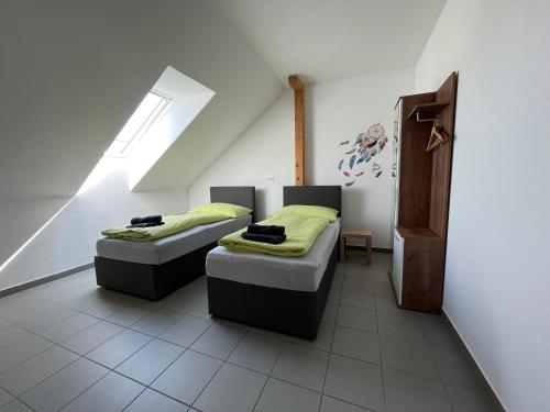 Cette chambre comprend 2 lits avec des draps verts et une fenêtre. dans l'établissement APARTMENTS RATZERSDORFER SEEN in 3100 SANKT PÖLTEN, à Sankt Pölten