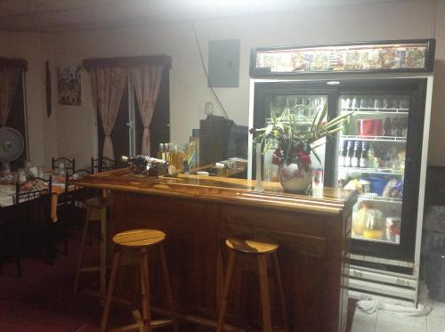 a kitchen with a bar with stools and a refrigerator at Beya Suites in Punta Gorda