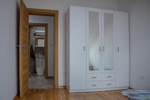 a room with white cabinets and a hallway at Apartman Mazić Nikšić in Nikšić