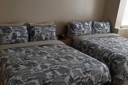 Duas camas sentadas uma ao lado da outra num quarto em London Luxury Apartment 3 Bed 1 minute walk from Redbridge Stn Free Parking em Wanstead