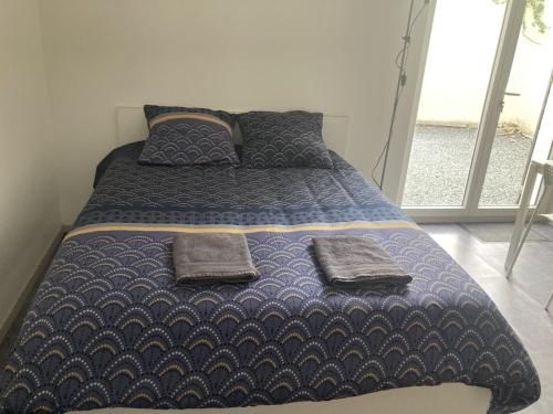 ein Bett mit zwei Kissen darauf in einem Schlafzimmer in der Unterkunft Studio le cosy centre de gaillon(wifi) in Gaillon