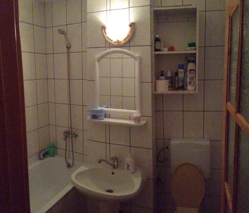 a bathroom with a sink and a toilet and a mirror at Apartament Slanic Moldova in Slănic-Moldova