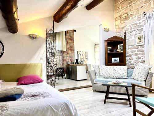 a bedroom with a bed and a couch and a table at Studio St Rémy Historic Center/Air-com in Saint-Rémy-de-Provence