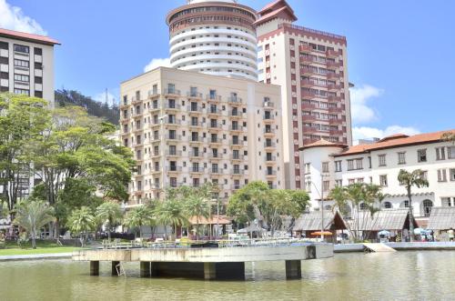 a bridge over a body of water in front of buildings at Hotel Guarany in Águas de Lindóia