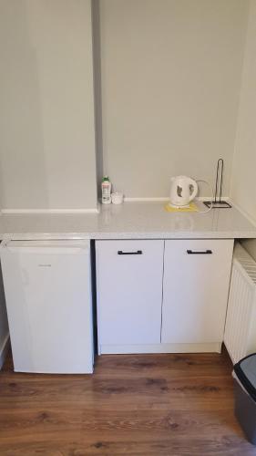 a kitchen with white cabinets and a counter top at Pokój Y in Stegna