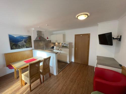 a small kitchen and dining room with a table and chairs at Gästehaus Pöll in Mayrhofen