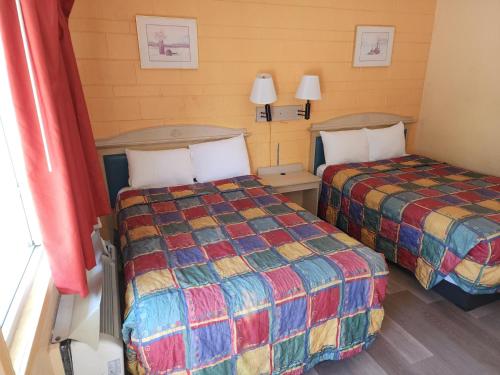 a hotel room with two beds and two lamps at Town House Motel in Lancaster