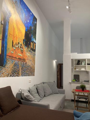 una sala de estar con sofá y una pintura en la pared en Golondrinas de Malaga "Apartamentos con mucho Arte" y terraza solarium en coliving, en Málaga