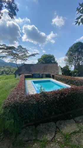 a house with a swimming pool in a field at Cabañita en el Parque Natural Ecocenter in Santandercito