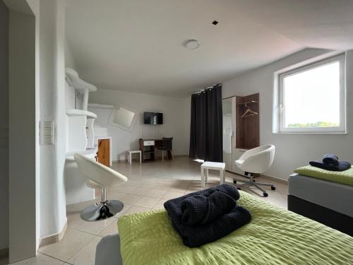 ein Schlafzimmer mit einem grünen Bett und ein Wohnzimmer in der Unterkunft APARTMENTS RATZERSDORFER SEEN in 3100 SANKT PÖLTEN in Sankt Pölten