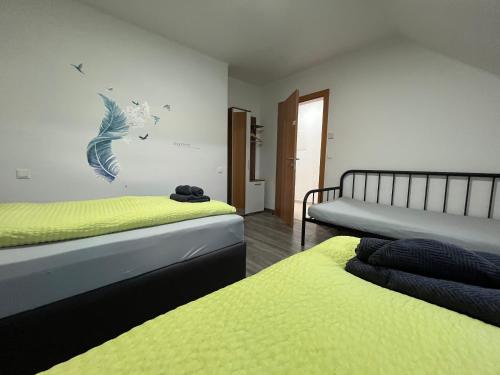 two beds in a room with yellow and blue at APARTMENTS RATZERSDORFER SEEN in 3100 SANKT PÖLTEN in Sankt Pölten