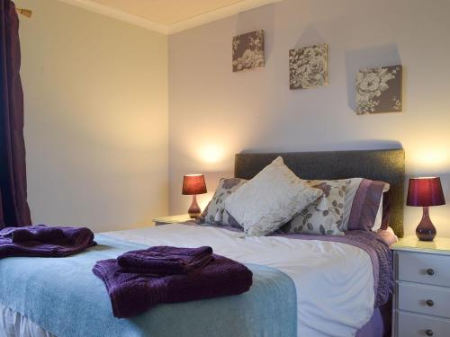 a bedroom with a bed with purple towels on it at Fair View in Lairg
