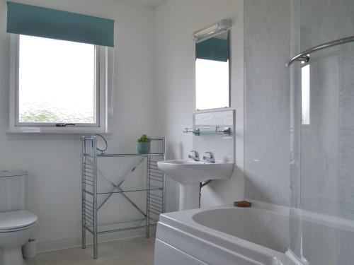 a white bathroom with a sink and a toilet at Fair View in Lairg