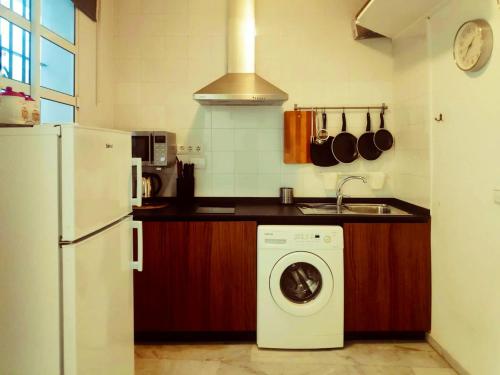 La cuisine est équipée d'un lave-linge et d'un réfrigérateur. dans l'établissement One bedroom apartement with city view balcony and wifi at Sevilla, à Séville