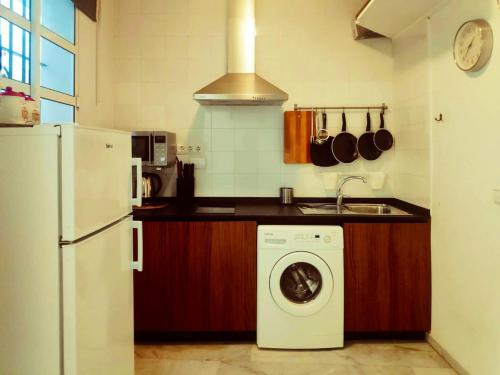 a kitchen with a washing machine and a refrigerator at One bedroom apartement with city view balcony and wifi at Sevilla in Seville