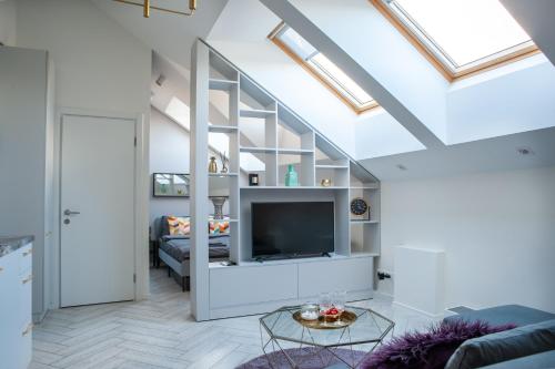 a living room with a loft conversion with a flat screen tv at E.M. Studio In City Center in Kaunas