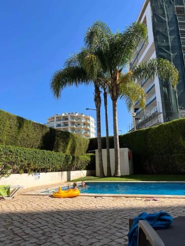 a swimming pool with two people in a yellow raft at Três palmeiras with pool in Portimão