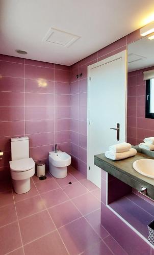 a pink bathroom with a toilet and a sink at Luxury Villa Sand Volcano in Villaverde