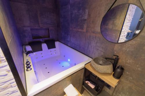 a bathroom with a tub and a mirror at Spa & Love - Balnéo - Queen size - Cocooning in Aulnat