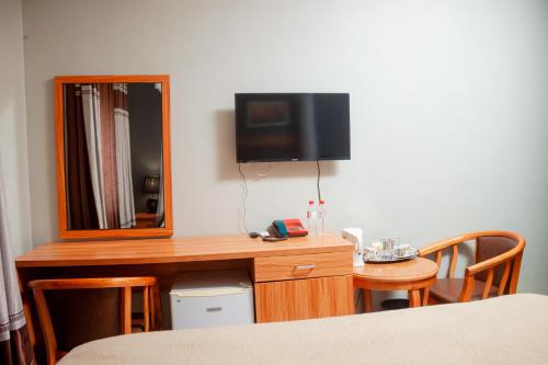 a room with a desk with a mirror and a tv at Top Lodge in Blantyre in Blantyre