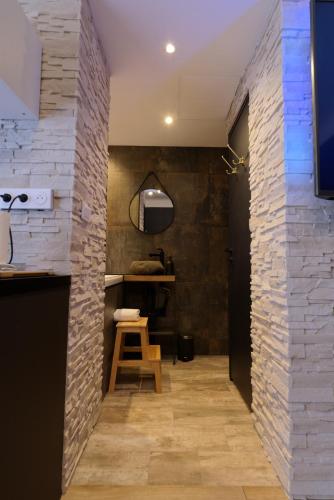 a hallway with a stone wall and a stool at Spa & Love - Balnéo - Queen size - Cocooning in Aulnat