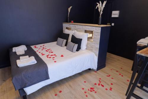 a bedroom with a bed with red rose petals on the floor at Spa & Love - Balnéo - Queen size - Cocooning in Aulnat