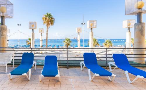 un grupo de sillas azules y el océano en Santa Margarita - Benisun, en Benidorm