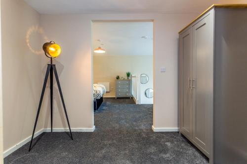 a room with a light on a tripod next to a door at The Arc - Stunning Luxury 2 Bed Duplex Apartment in Newcastle upon Tyne