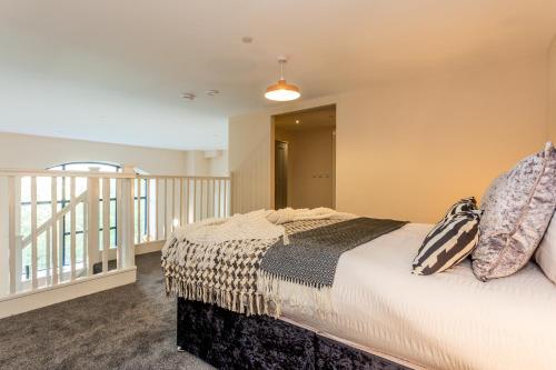 a bedroom with a bed with pillows on it at The Arc - Stunning Luxury 2 Bed Duplex Apartment in Newcastle upon Tyne