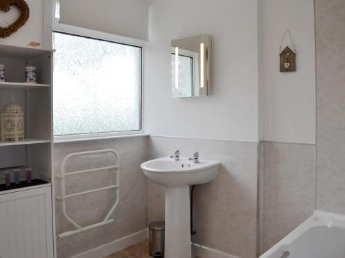 a white bathroom with a sink and a window at Mid Bishopton Cottage - Uk10910 in Whithorn