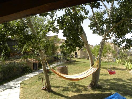 a hammock hanging between two trees in a yard at Borgo i Stritti in Petralia Soprana