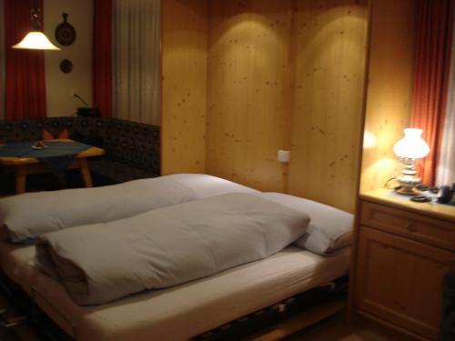 a bed in a room with a table and a lamp at Chasa Valetta in Samnaun