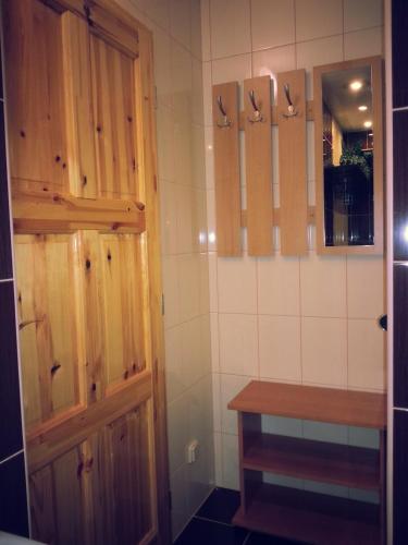 a bathroom with a wooden door and a table at Penzion Pod Boubínem in Kubova Huť