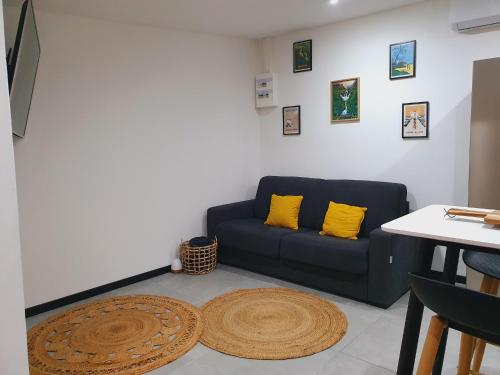 a living room with a blue couch and yellow pillows at ô Langevin , Logement avec véhicule in Saint-Joseph