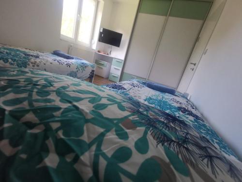a bedroom with a bed with a comforter on it at Villa EMIR in Sarajevo