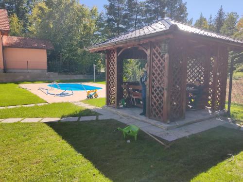 a wooden gazebo in a yard with a playground at Villa EMIR in Sarajevo
