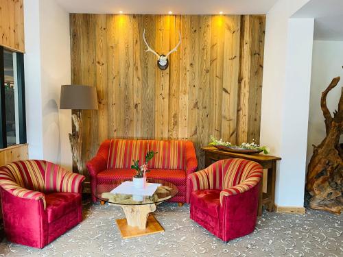 a living room with two red chairs and a table at Ferienwohnung Kogelblick Gosau in Gosau