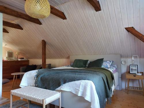 a bedroom with a bed in a room with wooden ceilings at Wanha Rojola in Syöte