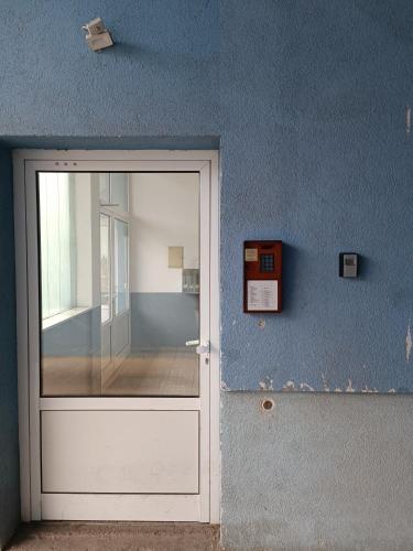 a white door in a blue wall at ARENA in Osijek