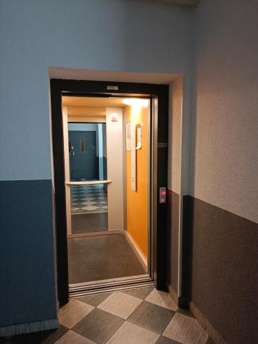 a hallway with an orange door and a mirror at ARENA in Osijek