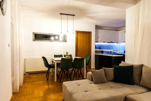 een woonkamer met een bank en een tafel met stoelen bij ARENA in Osijek