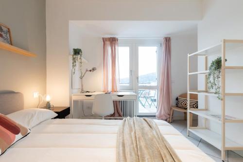 a bedroom with two beds and a desk and a window at Top Living Apartments - Carducci in Turin