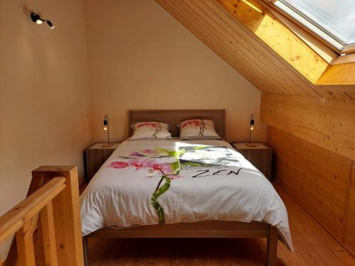 a bedroom with a bed with flowers on it at La clairière du lac, le bungalow de l'écureuil in Froid-Chapelle