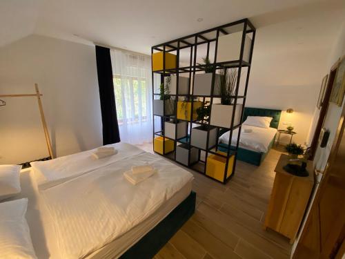 a bedroom with two beds and a shelf in the middle at Holiday home Casa Rio in Vinkovci