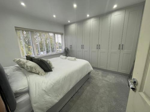 a bedroom with a bed with white cabinets and a window at Orchid House in Birmingham
