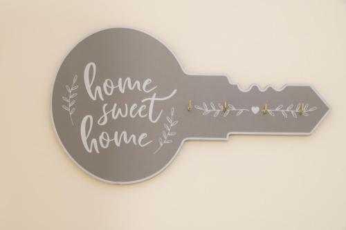a metal guitar shaped sign with the words home sweet home at Luxury 2-bedroom 2-bathroom city centre apartment in Lichfield